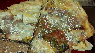 Лаваш, запеченный с оливковой пастой, томатным соусом, зеленью и кунжутом